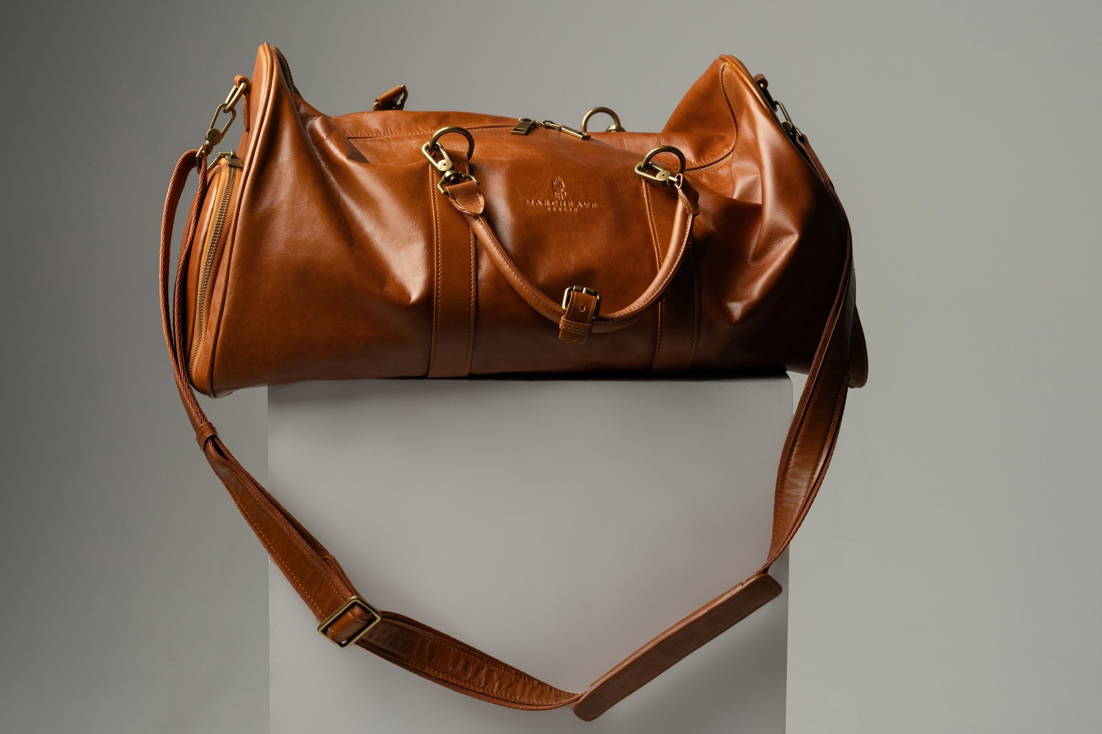 The Transformable Weekender in Cognac, shown with its detachable shoulder strap